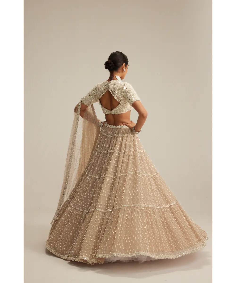 VVANI VATS- Light Beige Pearl Drop Multi Tier Lehenga With High Neck Blouse Set.